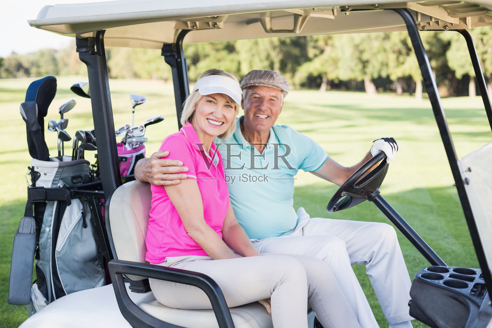 一对愉快的成熟夫妇坐在高尔夫球车里照片摄影图片