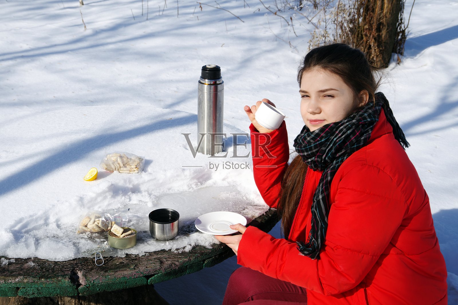一个年轻的女孩正在冬季的风景上休息。照片摄影图片