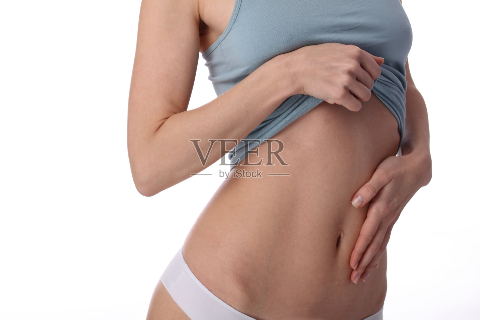 健康女性身材，腰围。身材苗条的女性躯干、腰部、腹部、腹部收起来。运动，健身，节食结果，积极的生活方式概念照片摄影图片