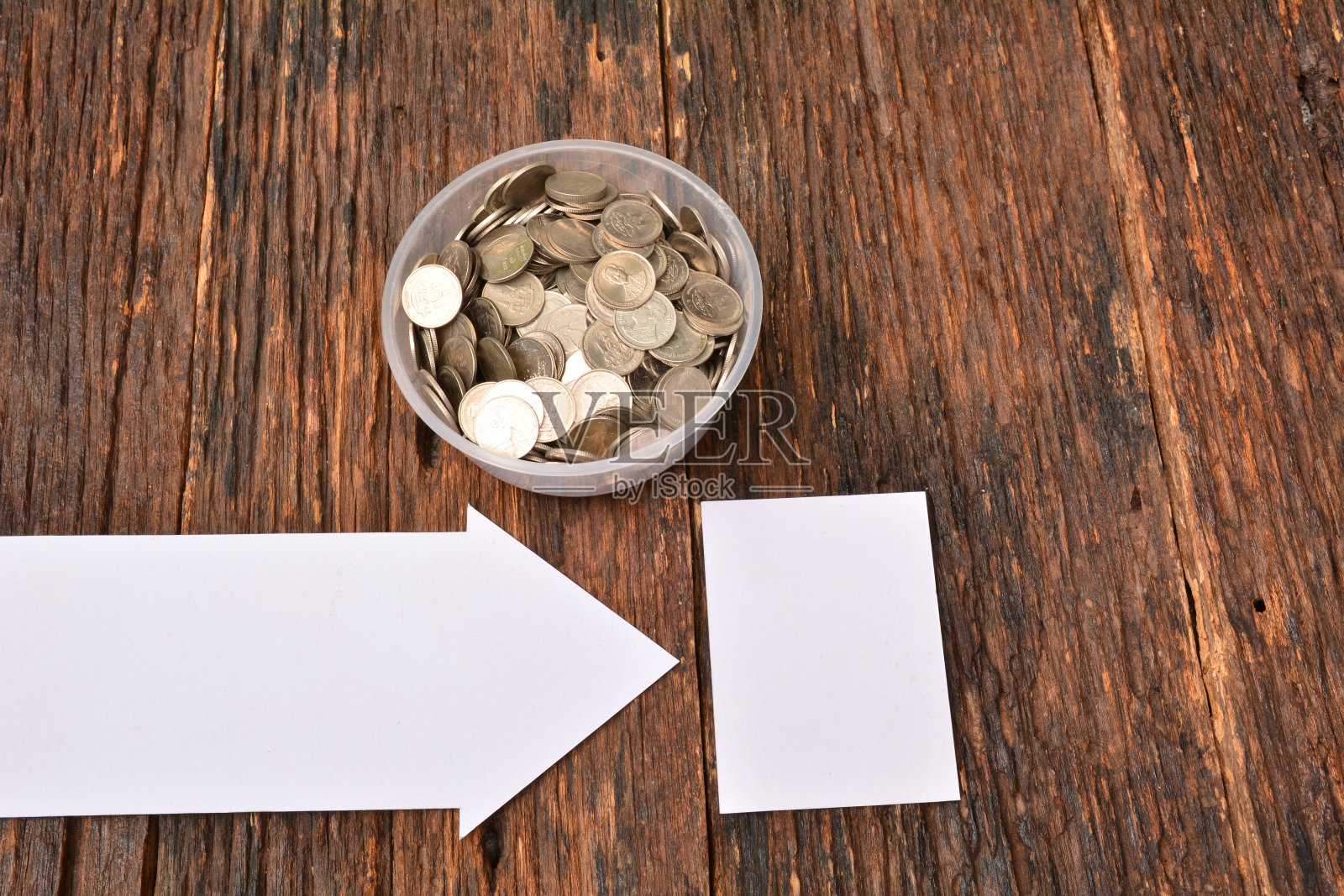 用白纸把硬币堆在玻璃杯里照片摄影图片