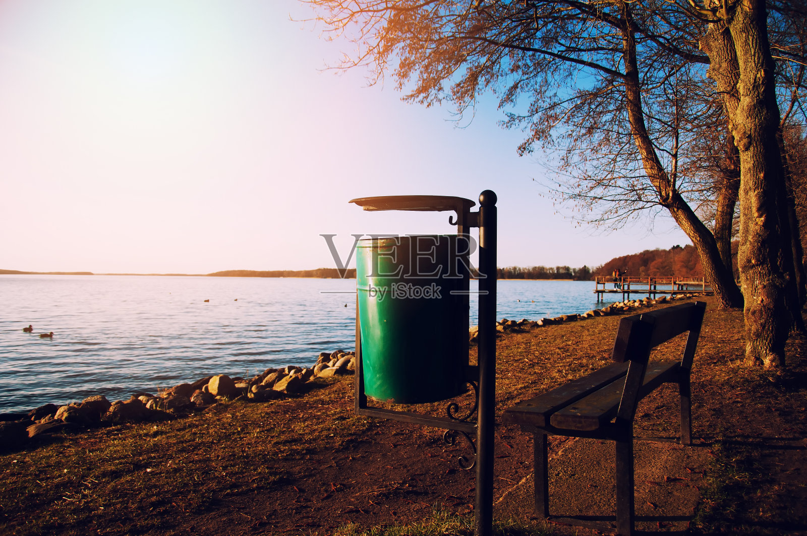 湖边的木凳和绿色垃圾桶照片摄影图片