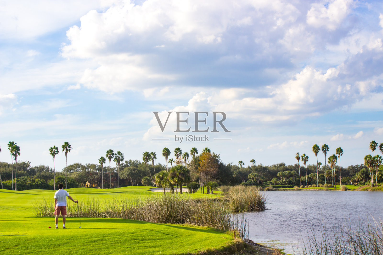 年轻的高尔夫球手在美丽的高尔夫球场照片摄影图片