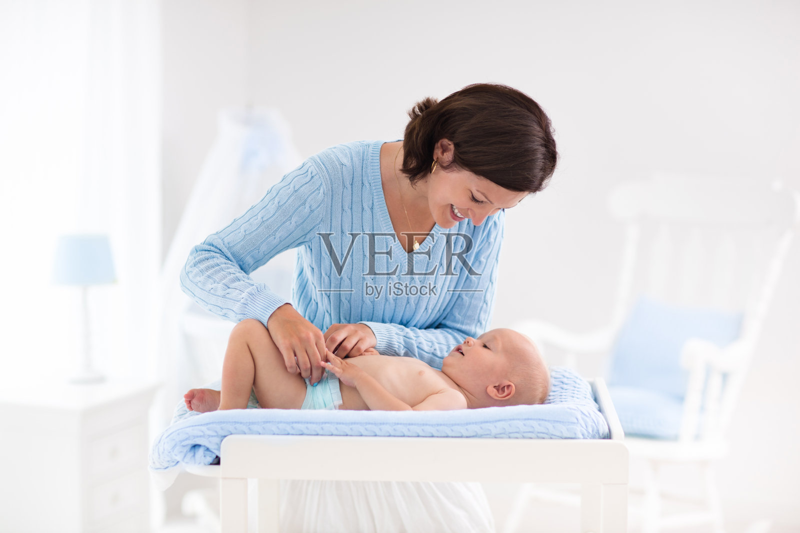 妈妈给男婴换尿布照片摄影图片