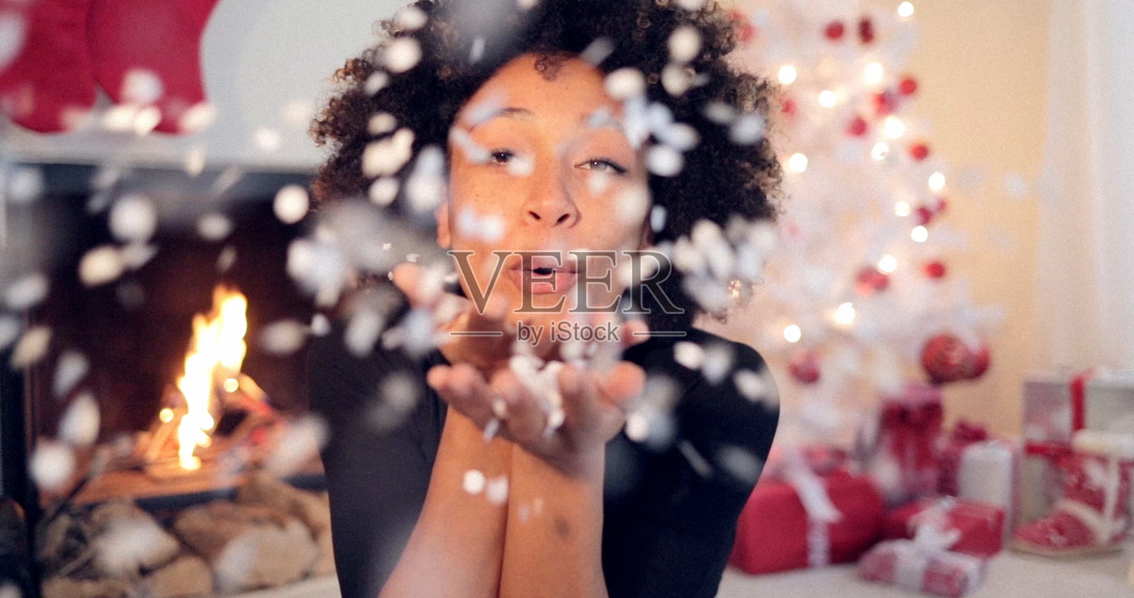 年轻女子吹掉手上的五彩纸屑照片摄影图片