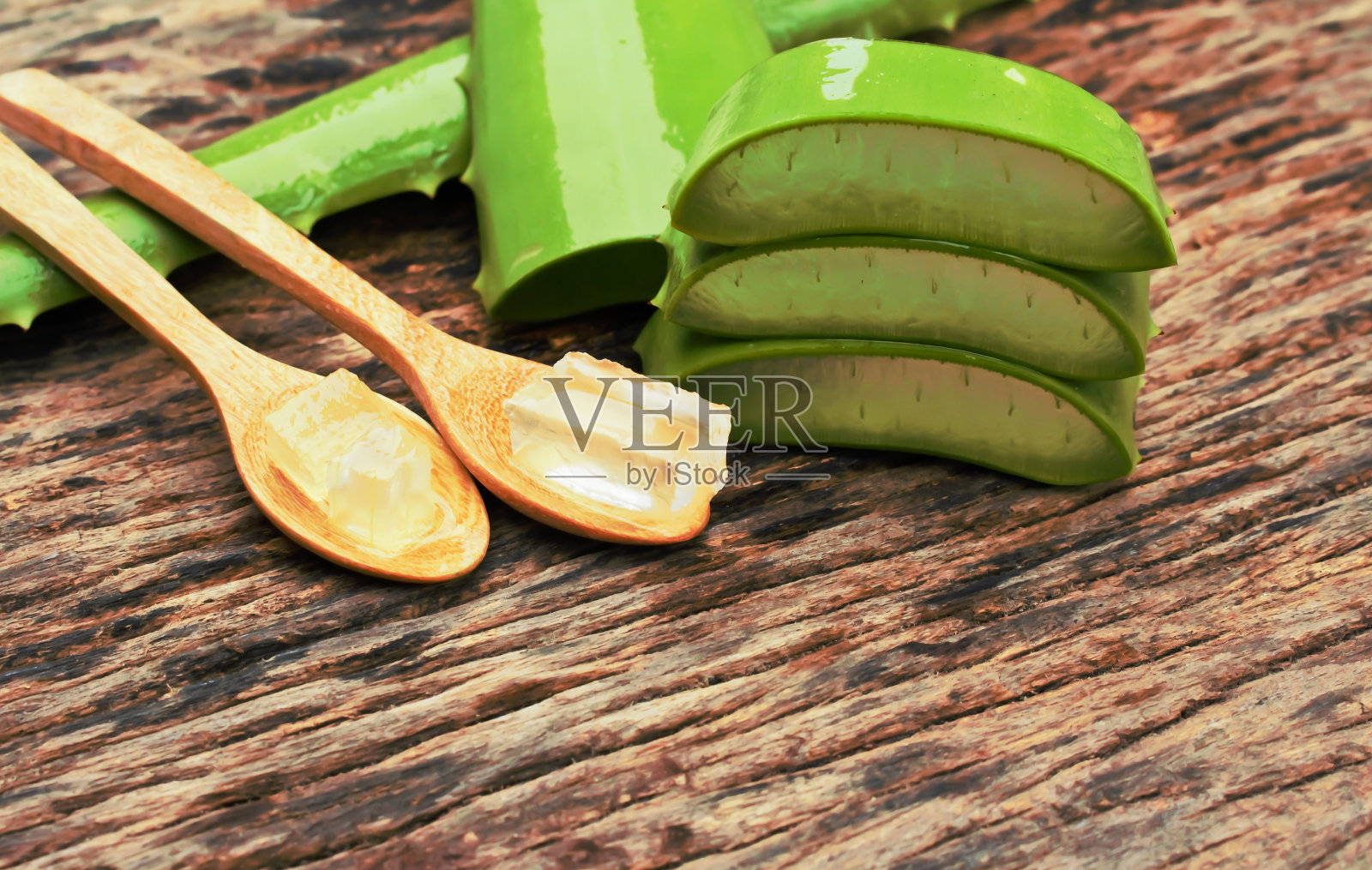 芦荟胶在木勺与桌子照片摄影图片