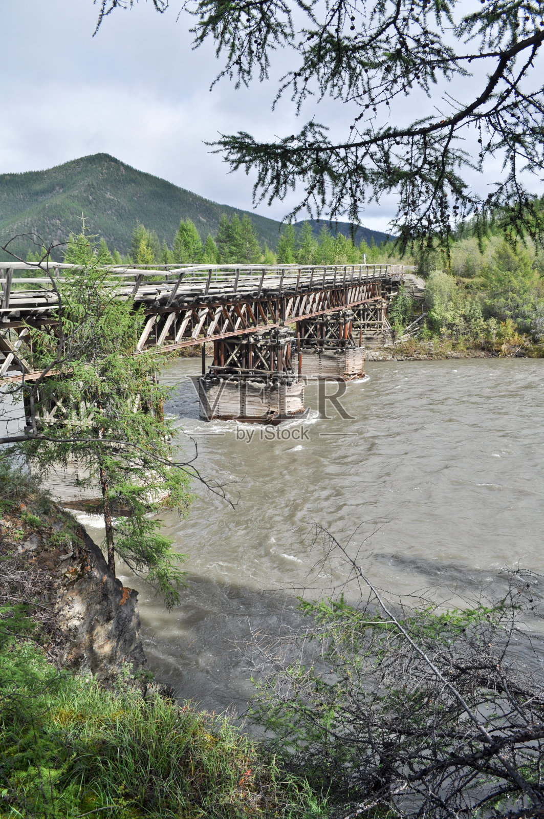 木桥横跨雅库特山脉的河流。照片摄影图片