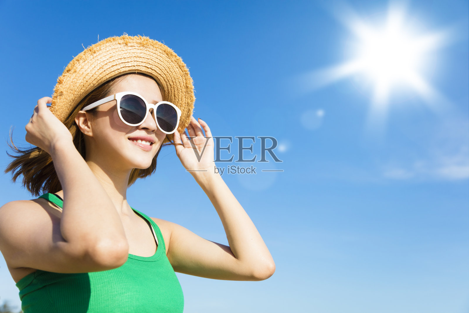 在夏天放松身心，沐浴阳光的年轻女子照片摄影图片