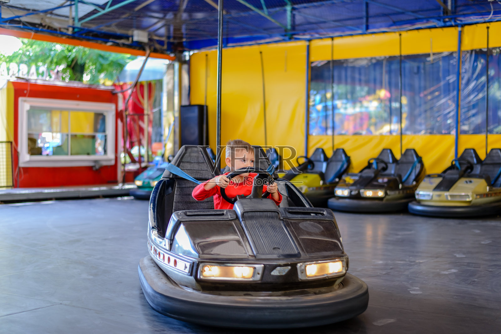 小男孩在碰碰车里玩照片摄影图片