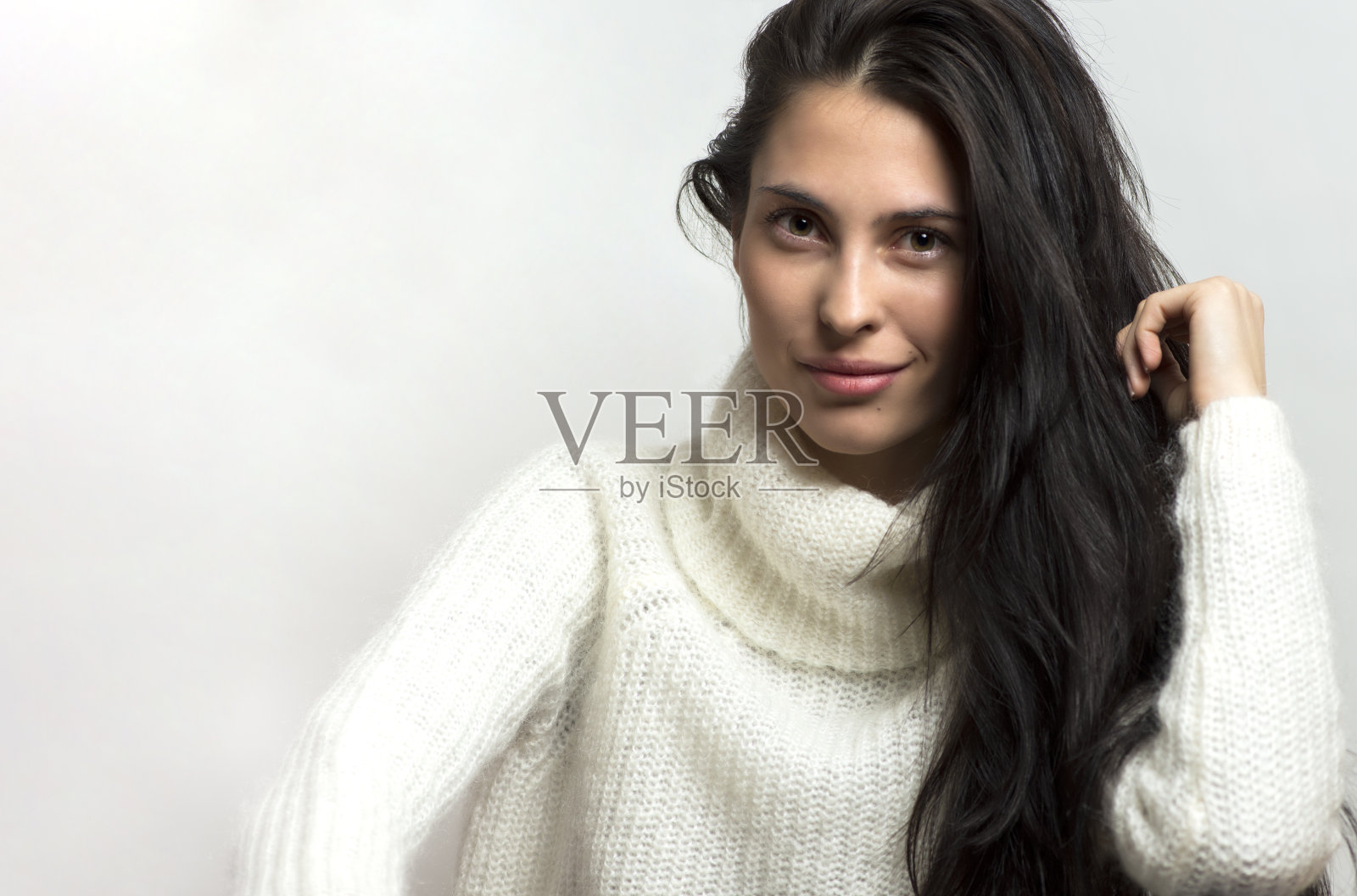 美丽的黑发女人强烈的近距离肖像在白色的背景。照片摄影图片