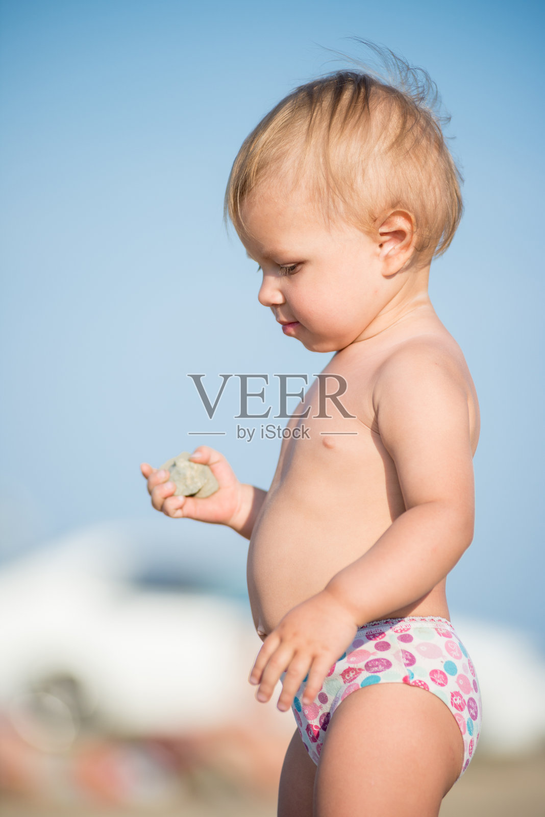 可爱的婴儿在海滩上玩玩具照片摄影图片