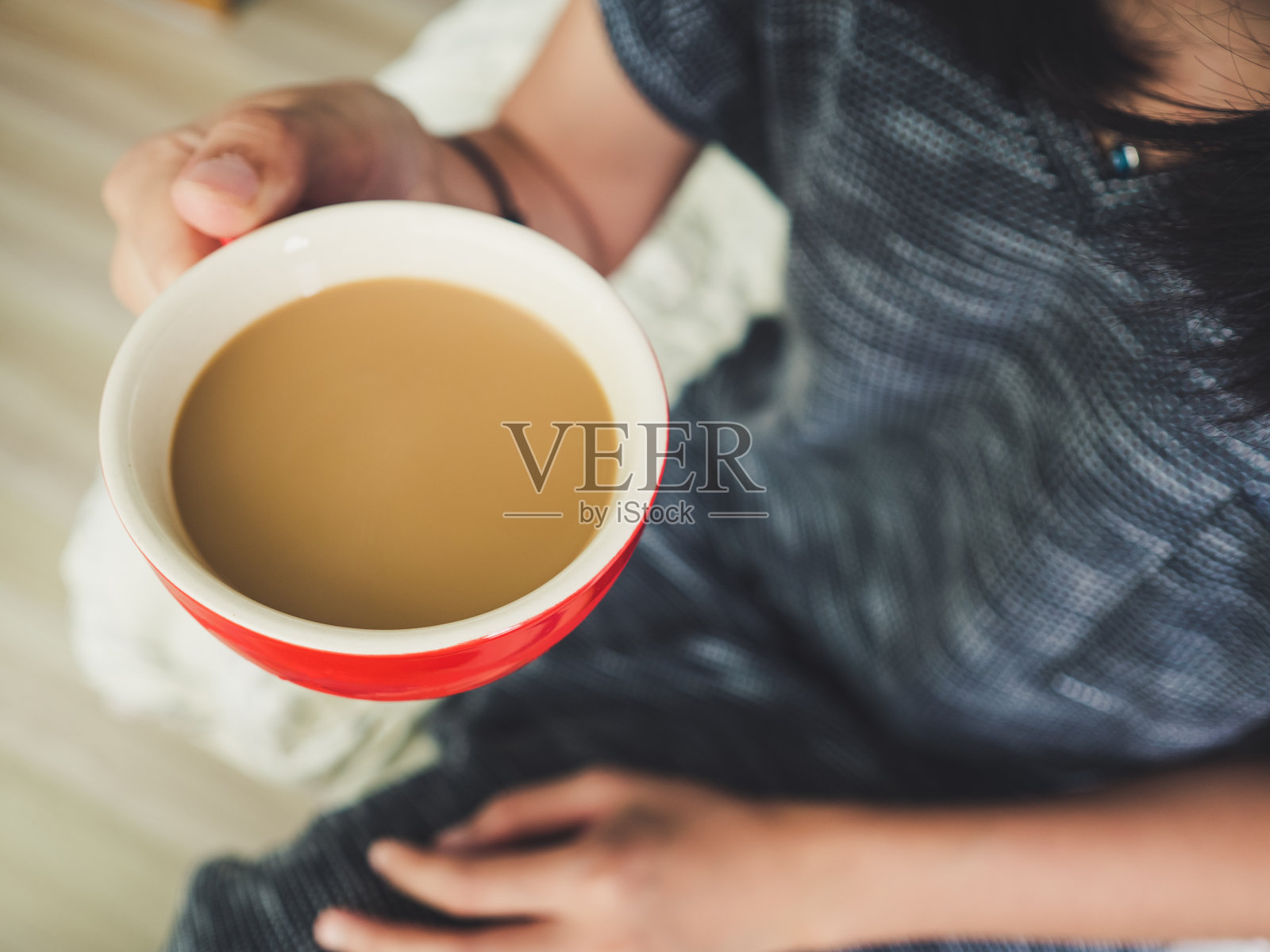 女人拿着一杯红咖啡。照片摄影图片