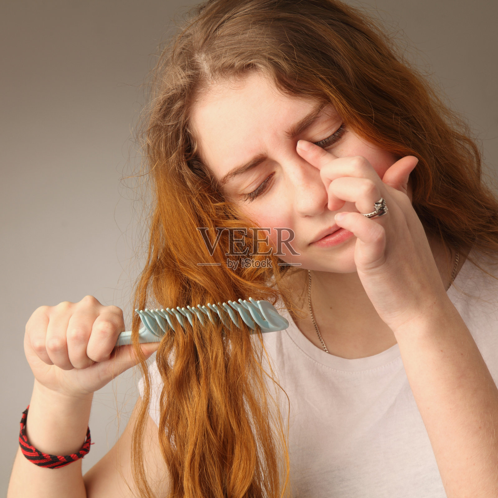 年轻紧张的女人梳理着她的头发照片摄影图片