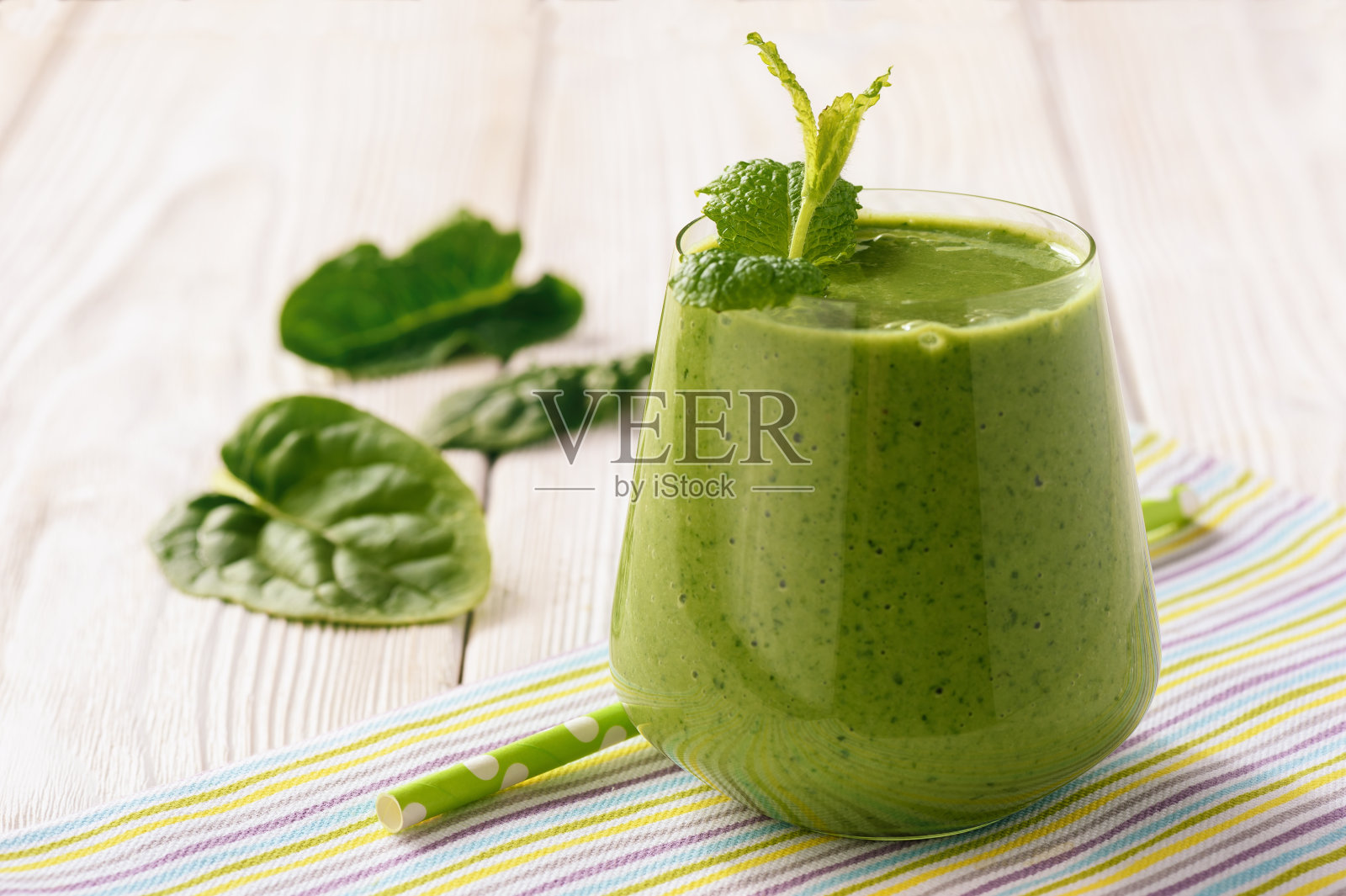 健康食物——木桌上的菠菜奶昔。照片摄影图片