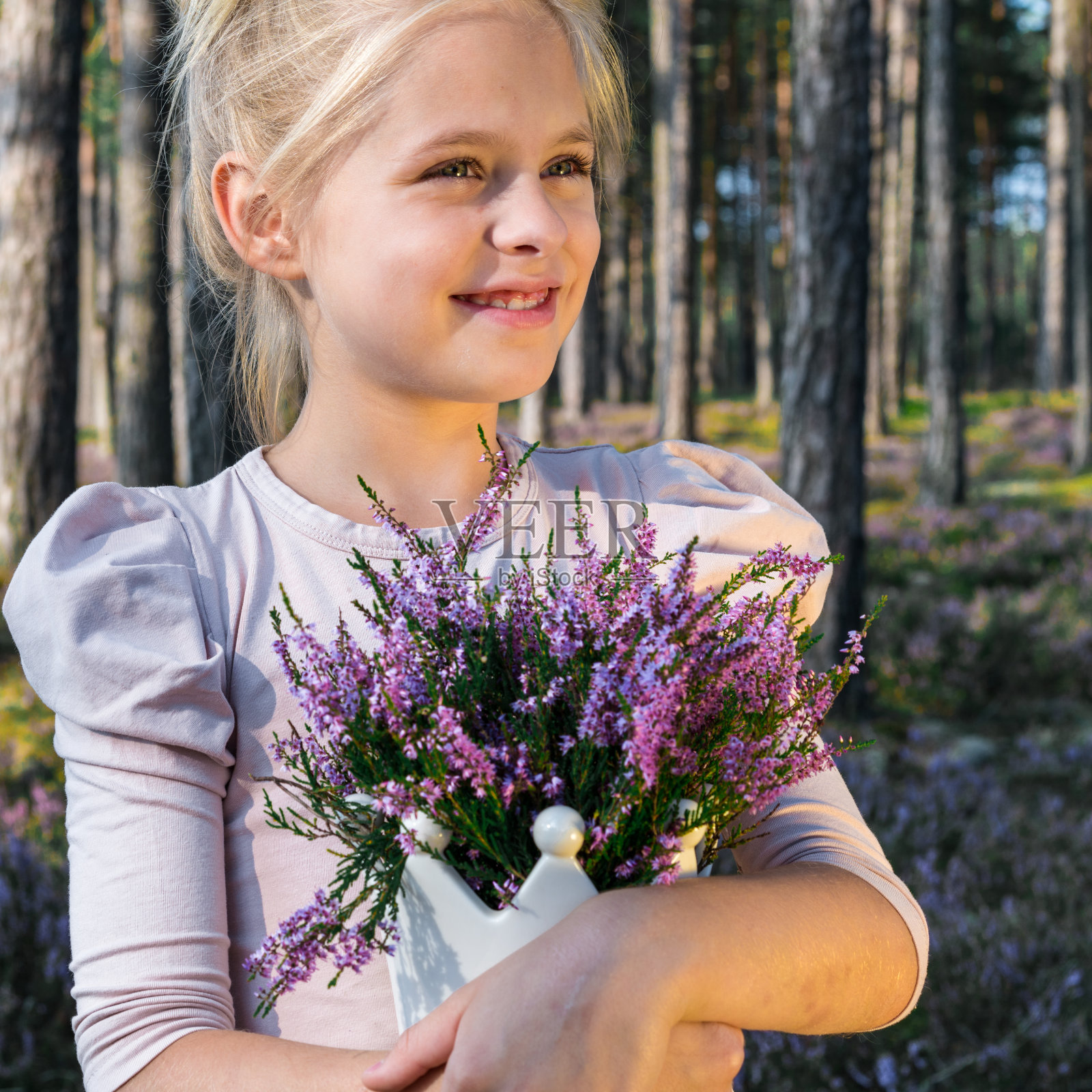美丽的女孩在森林里拿着一个花瓶照片摄影图片