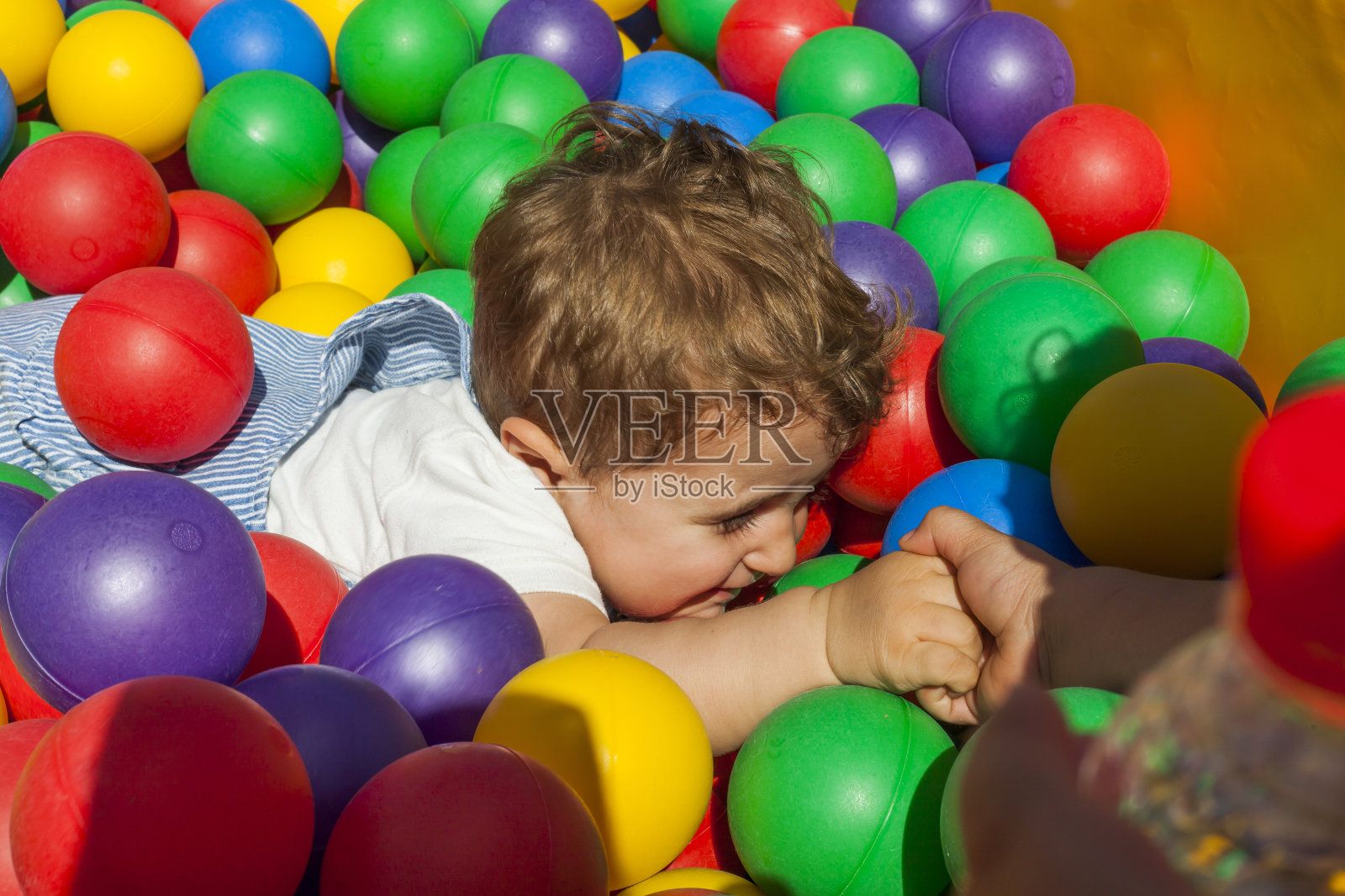 女孩在帮她弟弟把球池拿出来照片摄影图片