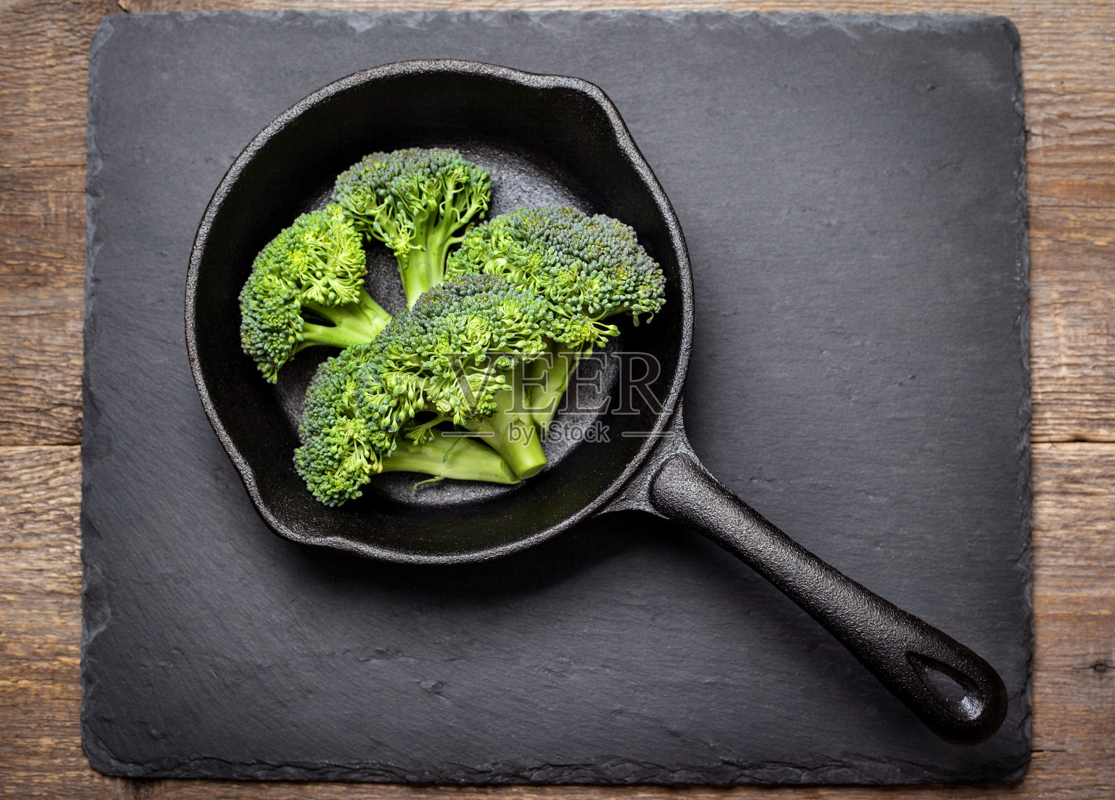 新鲜的西兰花在铸铁平底锅照片摄影图片
