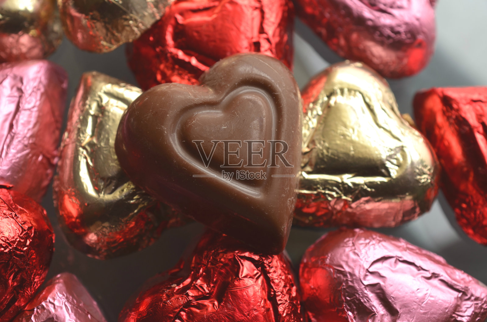 心形的巧克力箔纸包裹着红色、粉色、金色、银色照片摄影图片