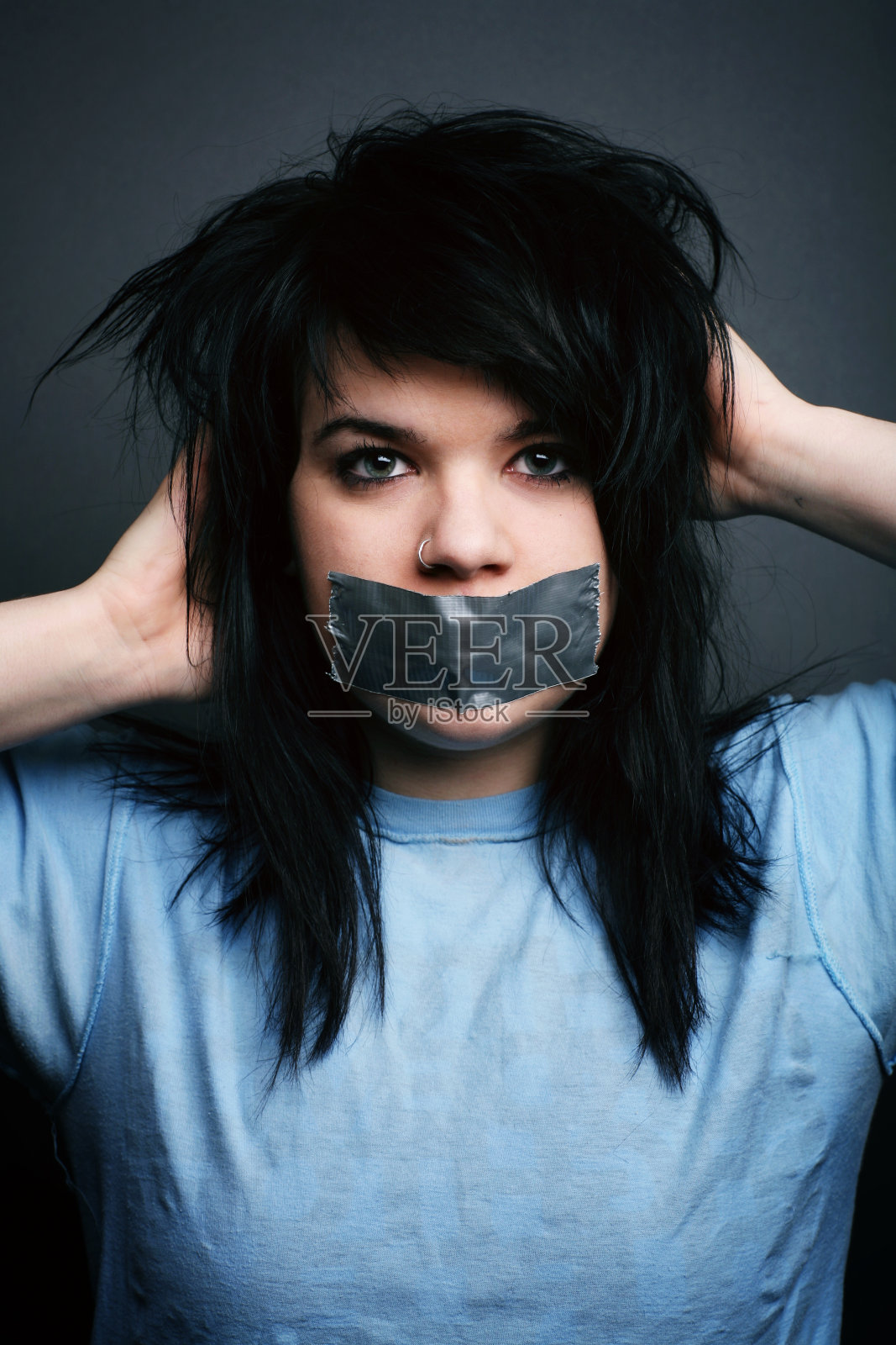 黑头发女性，用鸭胶带盖住嘴照片摄影图片