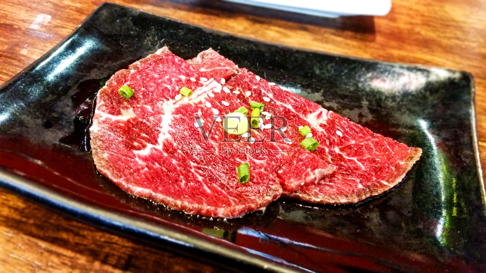 鲜红的生牛肉片在菜桌上照片摄影图片