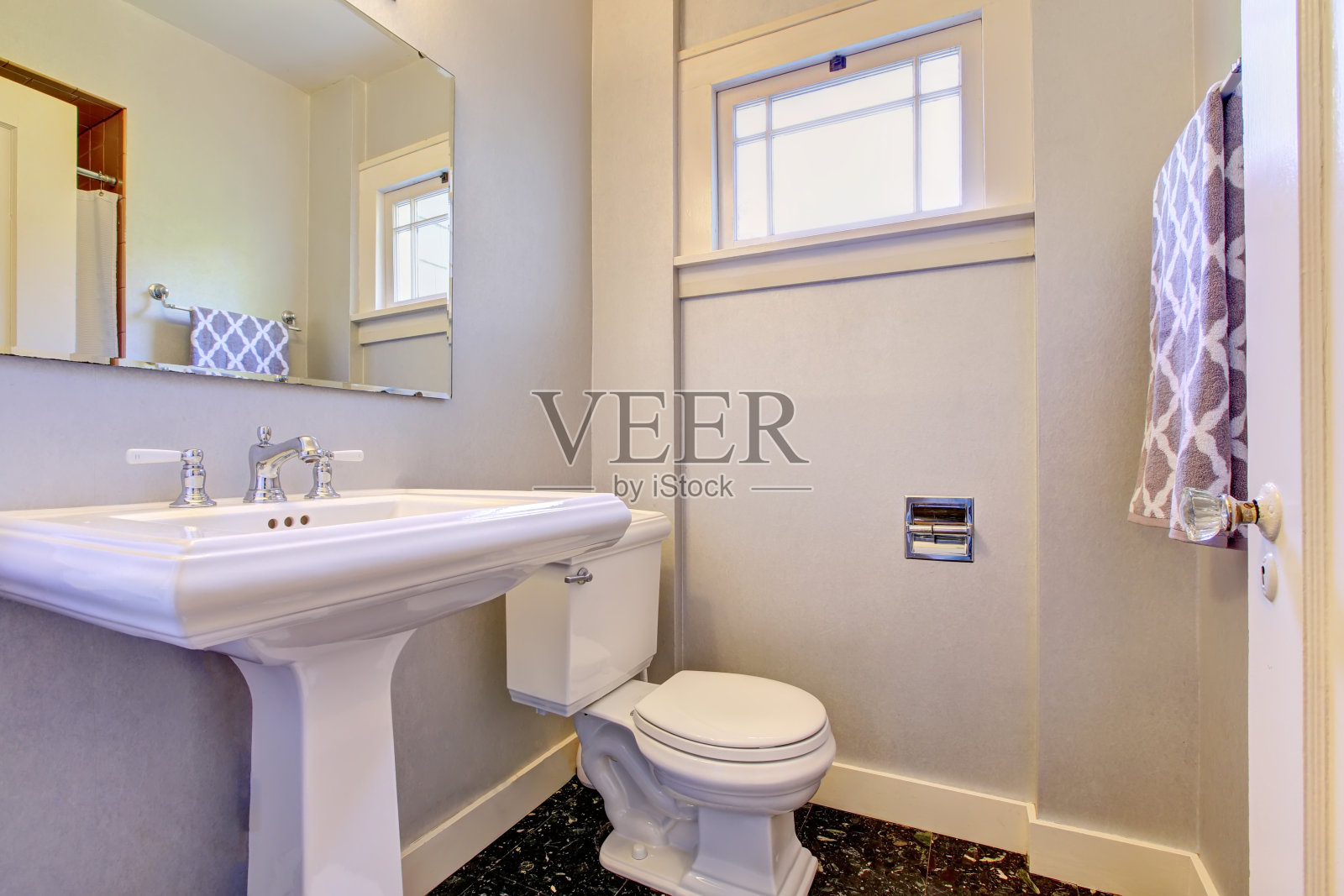 浴室采用浅紫色色调，地板采用深色大理石瓷砖。照片摄影图片