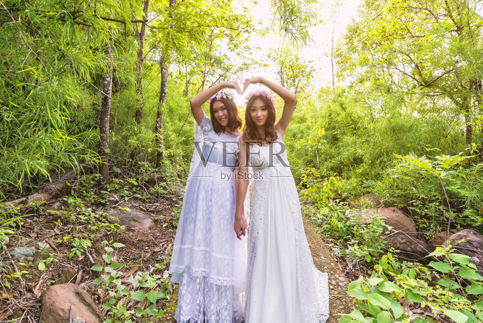 穿着带花朵的白色连衣裙的漂亮年轻女子照片摄影图片