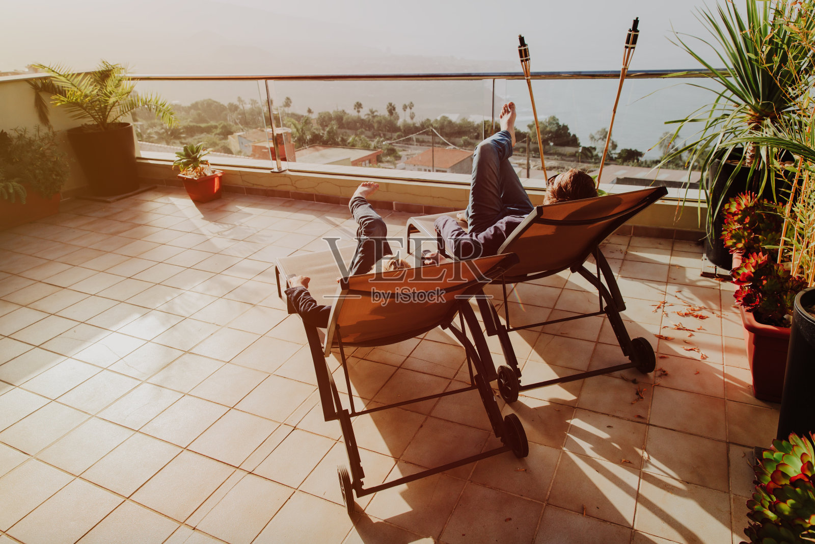 日落时分，爸爸和儿子在阳台阳台上休息照片摄影图片
