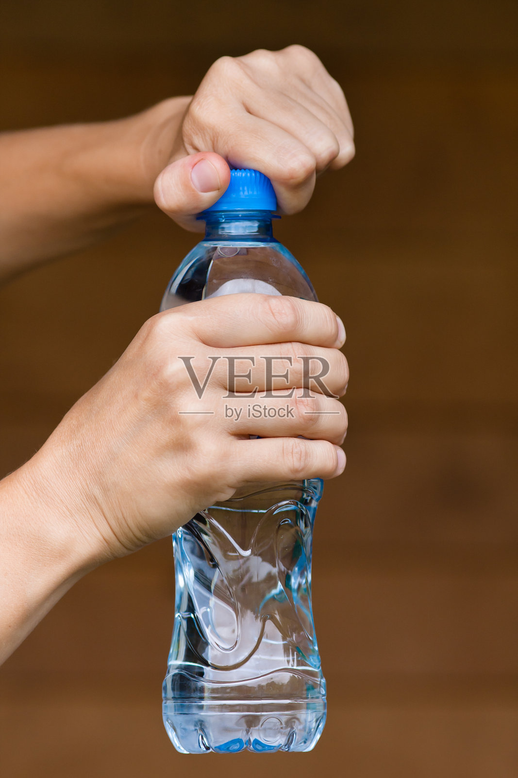 双手打开装有水的瓶子照片摄影图片