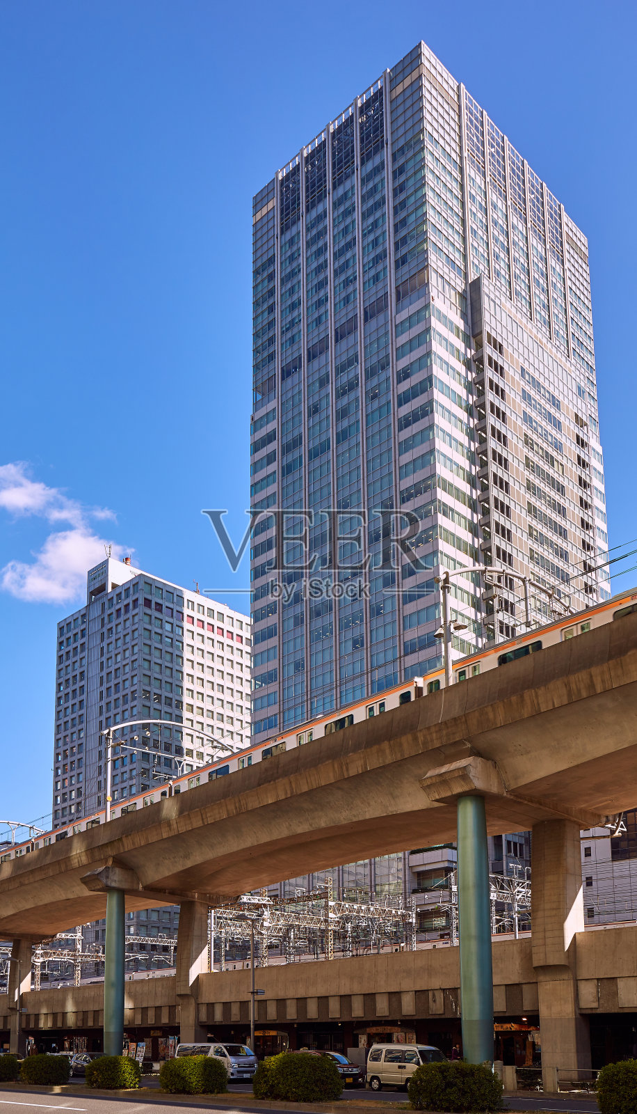 东京典型的多层公路，在冬季的蓝天下，有火车、汽车和摩天大楼照片摄影图片