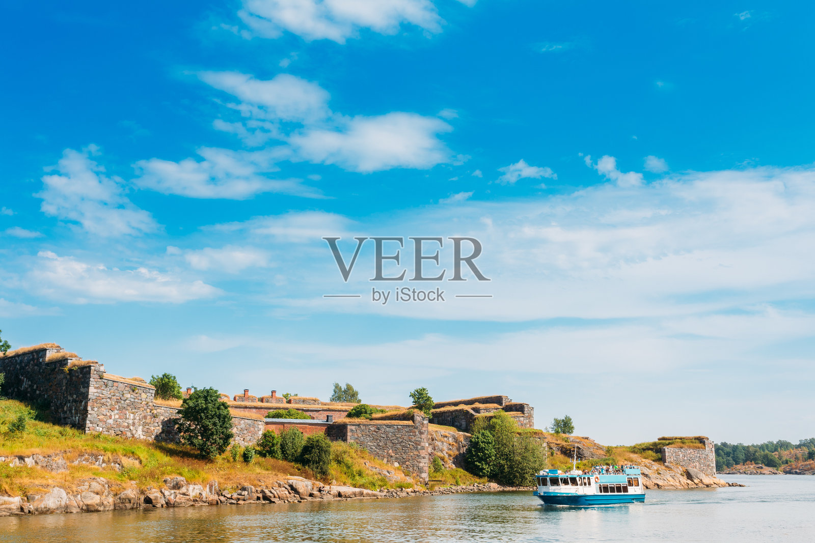 游船漂浮在索欧门里纳的海上堡垒附近。照片摄影图片