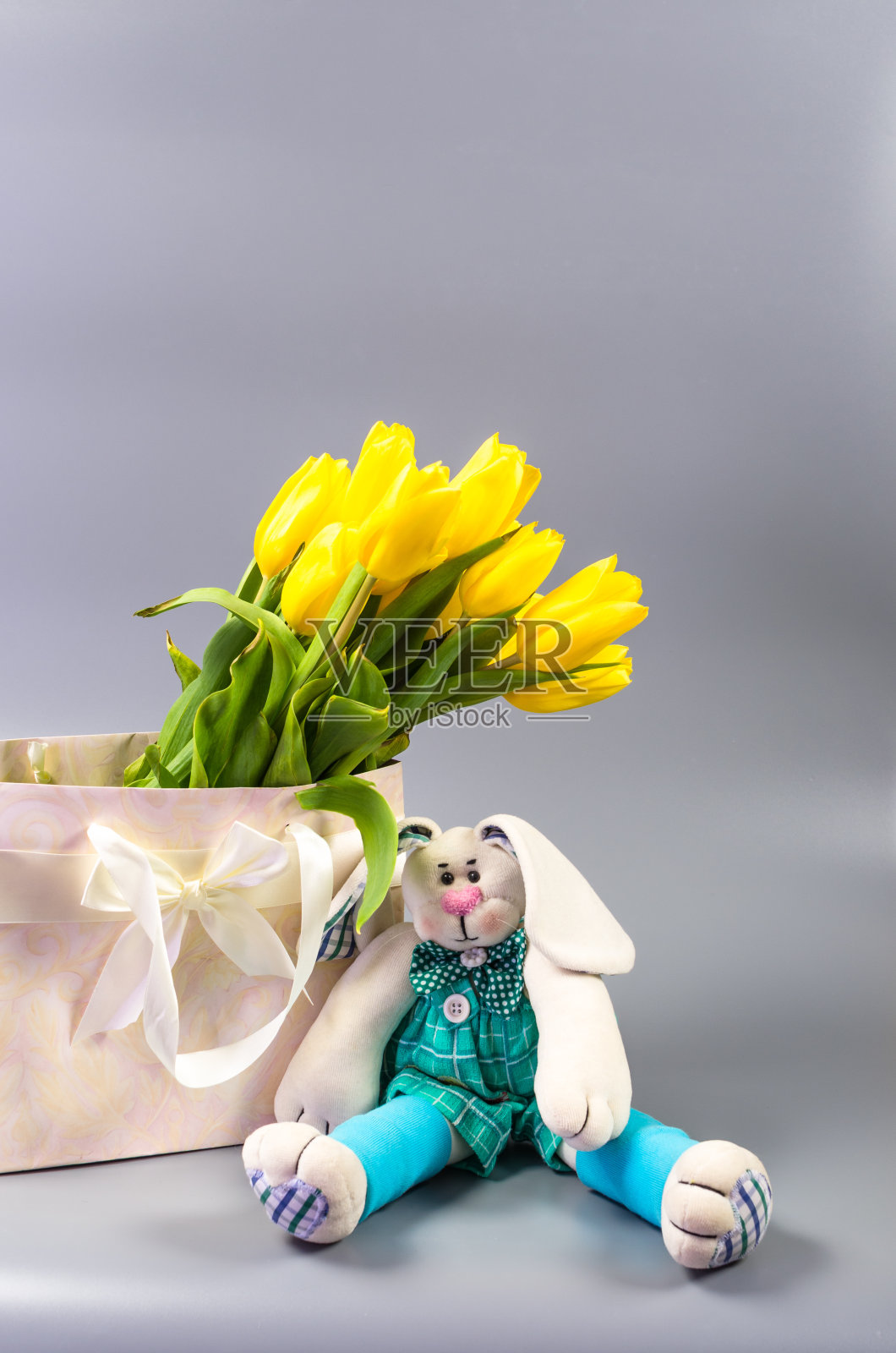 礼物袋里的毛绒玩具和黄色郁金香照片摄影图片