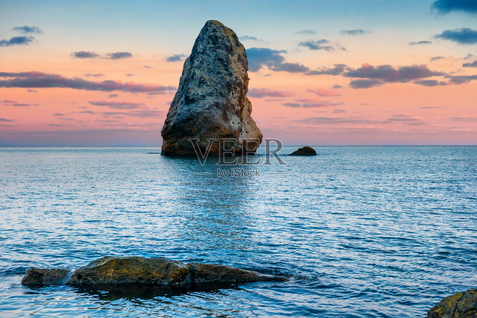 日落在海上的大岩石之上照片摄影图片