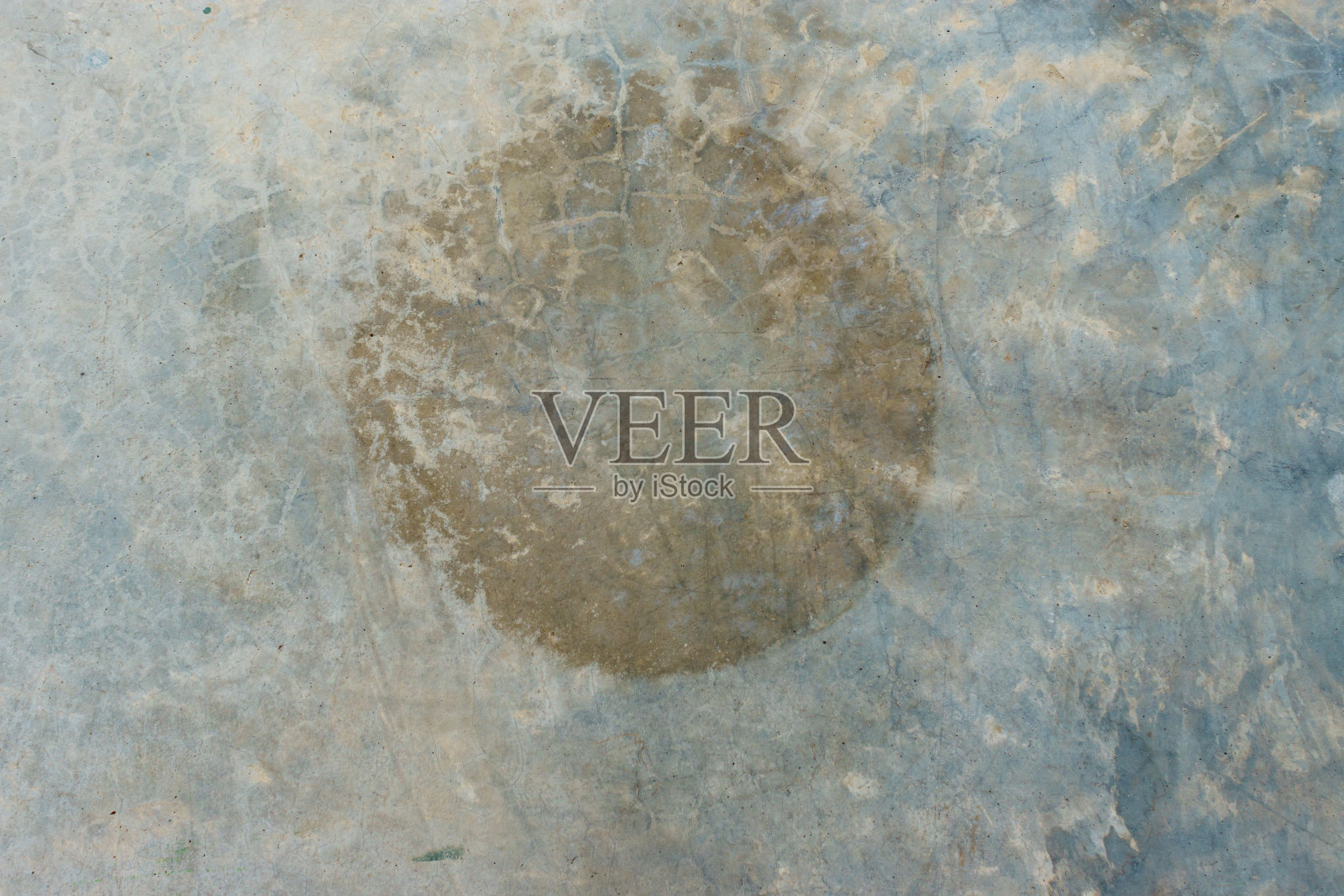 在抛光的旧灰色混凝土地板上圈出棕色锈斑照片摄影图片