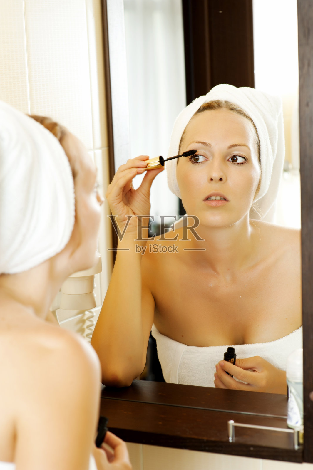 年轻女子在涂睫毛膏照片摄影图片