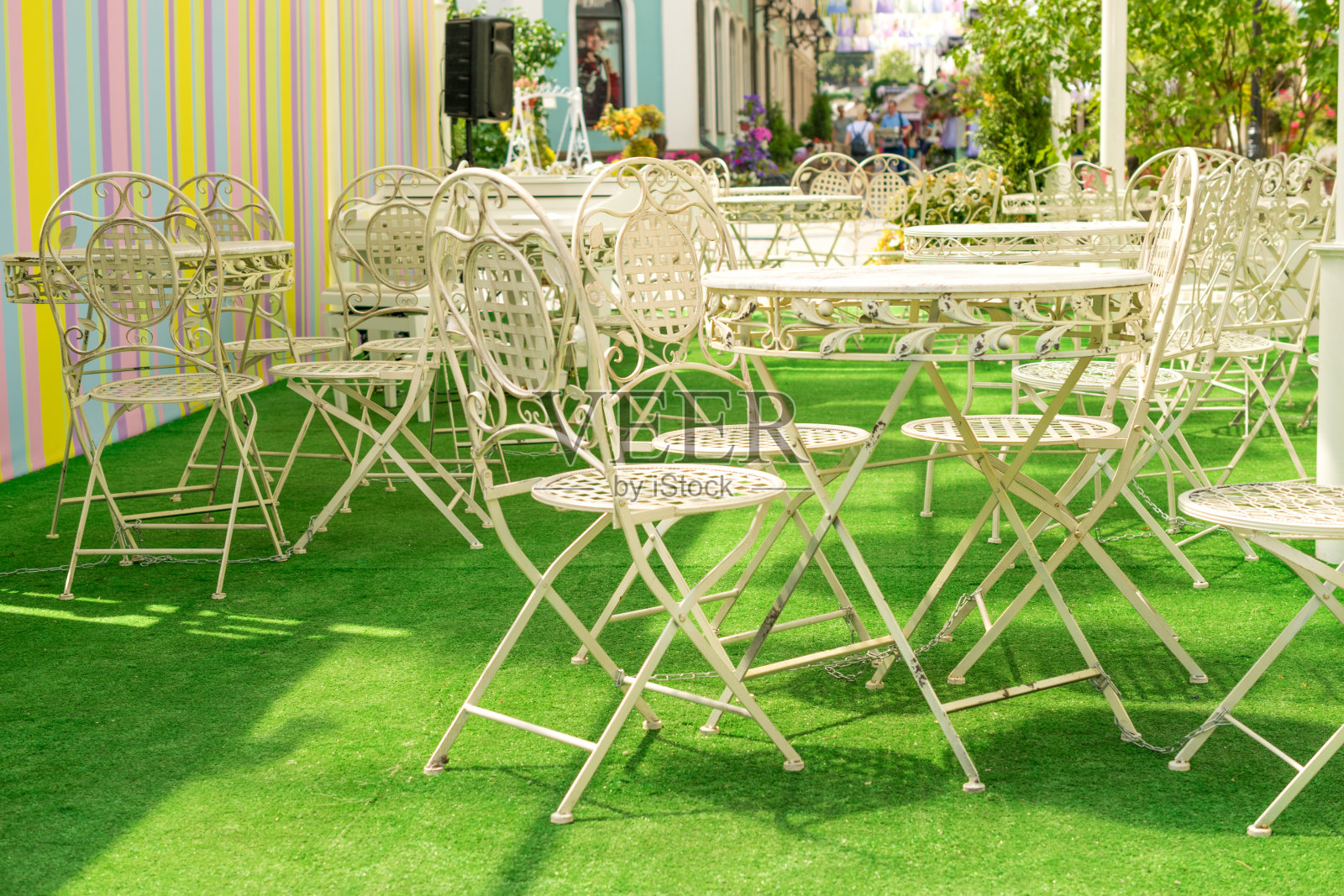 咖啡馆阳台上的绿色金属桌子，椅子和雨伞照片摄影图片