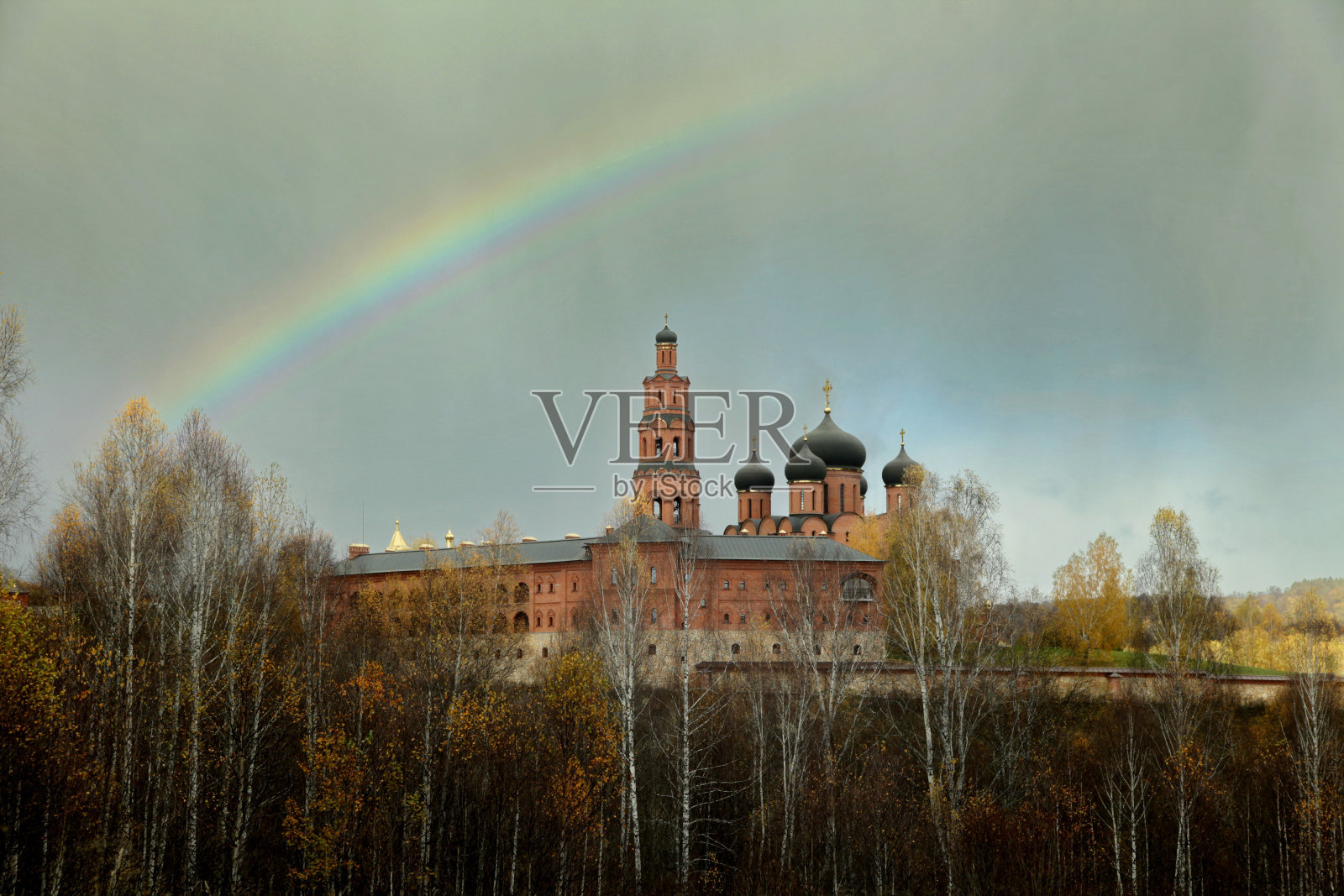 在阴天的秋天，东正教修道院上空有彩虹照片摄影图片