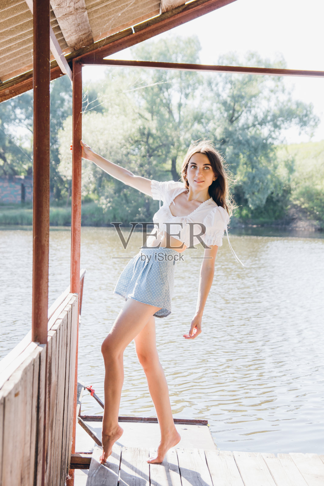 湖上凉亭里的美丽女孩照片摄影图片