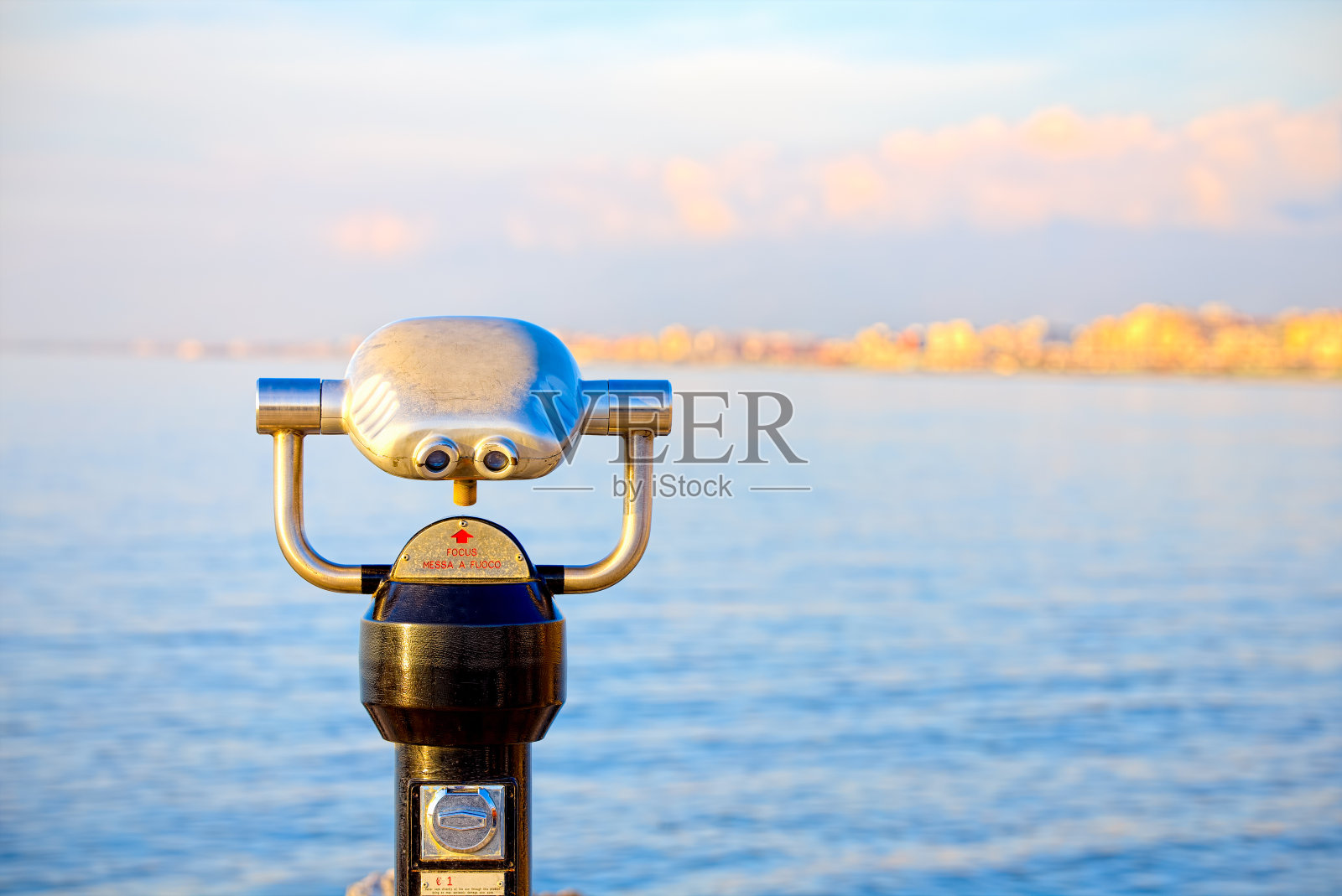 日落时分，维亚雷吉欧码头上的投币式望远镜照片摄影图片