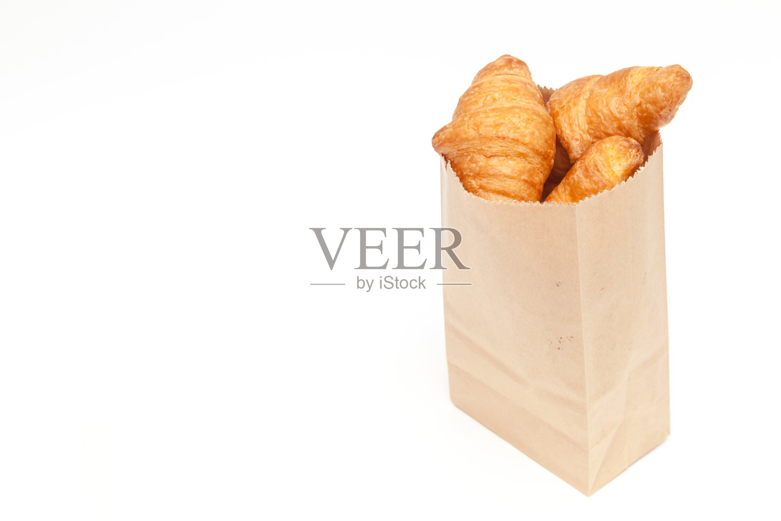 牛角面包在牛皮纸袋上白色的背景孤立照片摄影图片