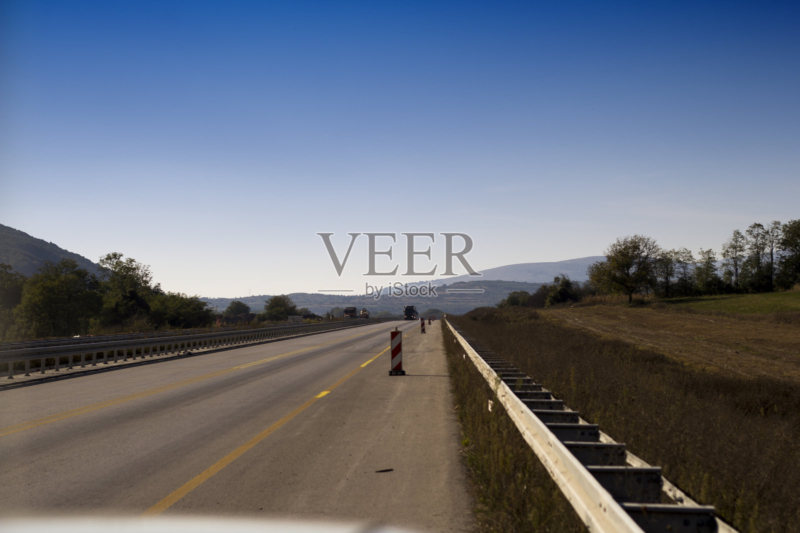 蓝天下的新沥青公路。照片摄影图片