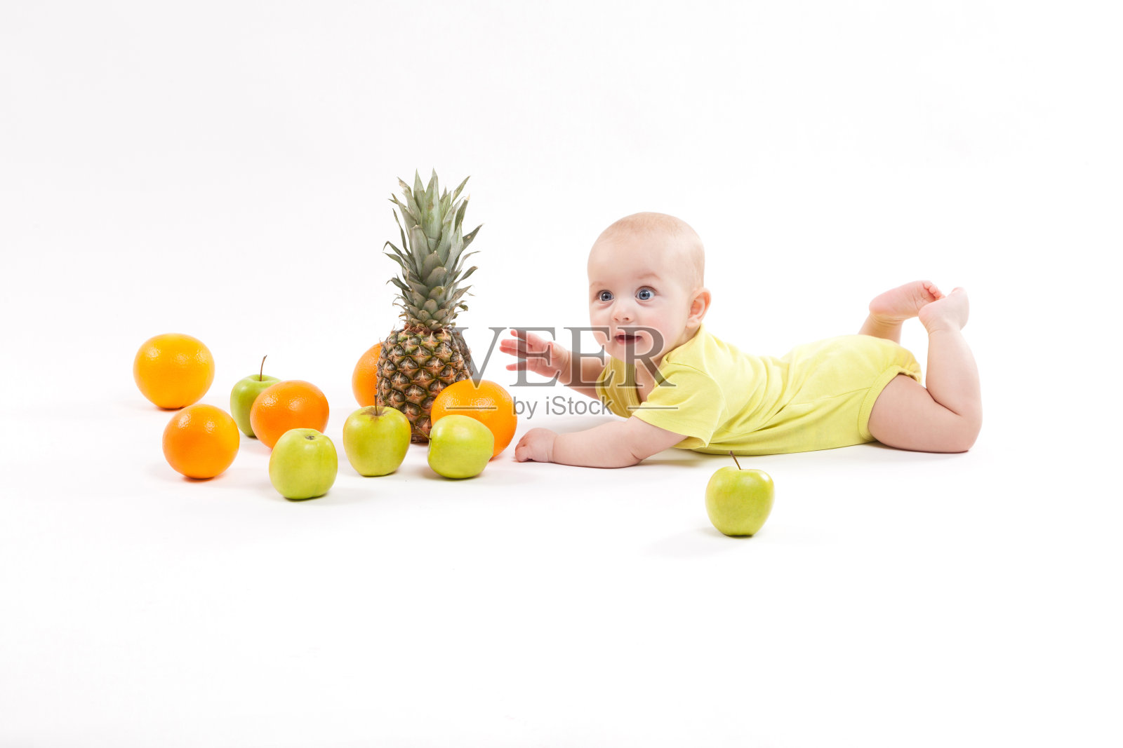 婴儿被白色背景的水果包围着照片摄影图片