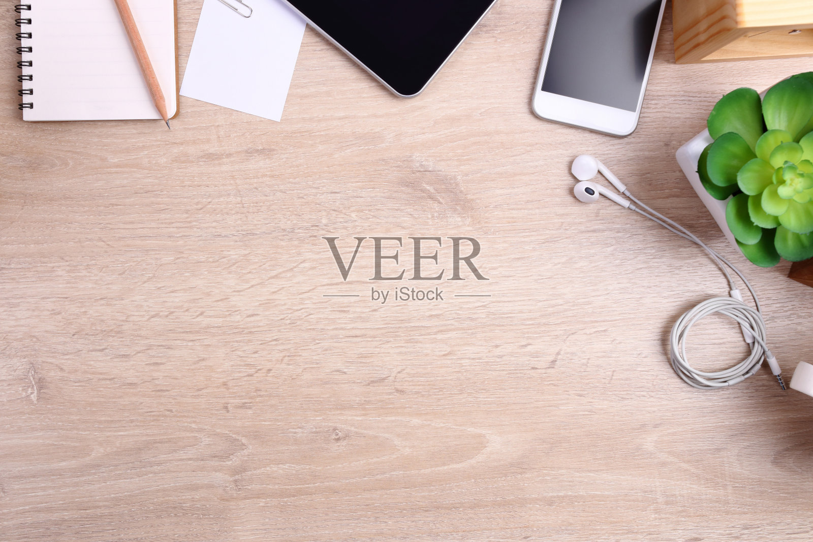 木制背景的智能手机、平板电脑和办公用品照片摄影图片