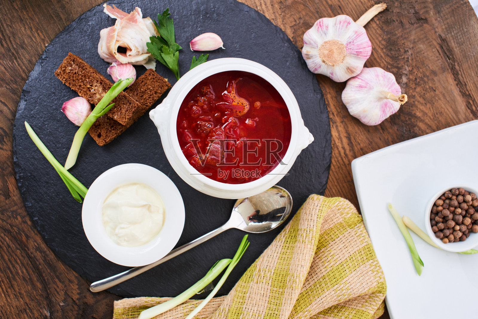 白盘子里的红汤和大蒜熏肉照片摄影图片