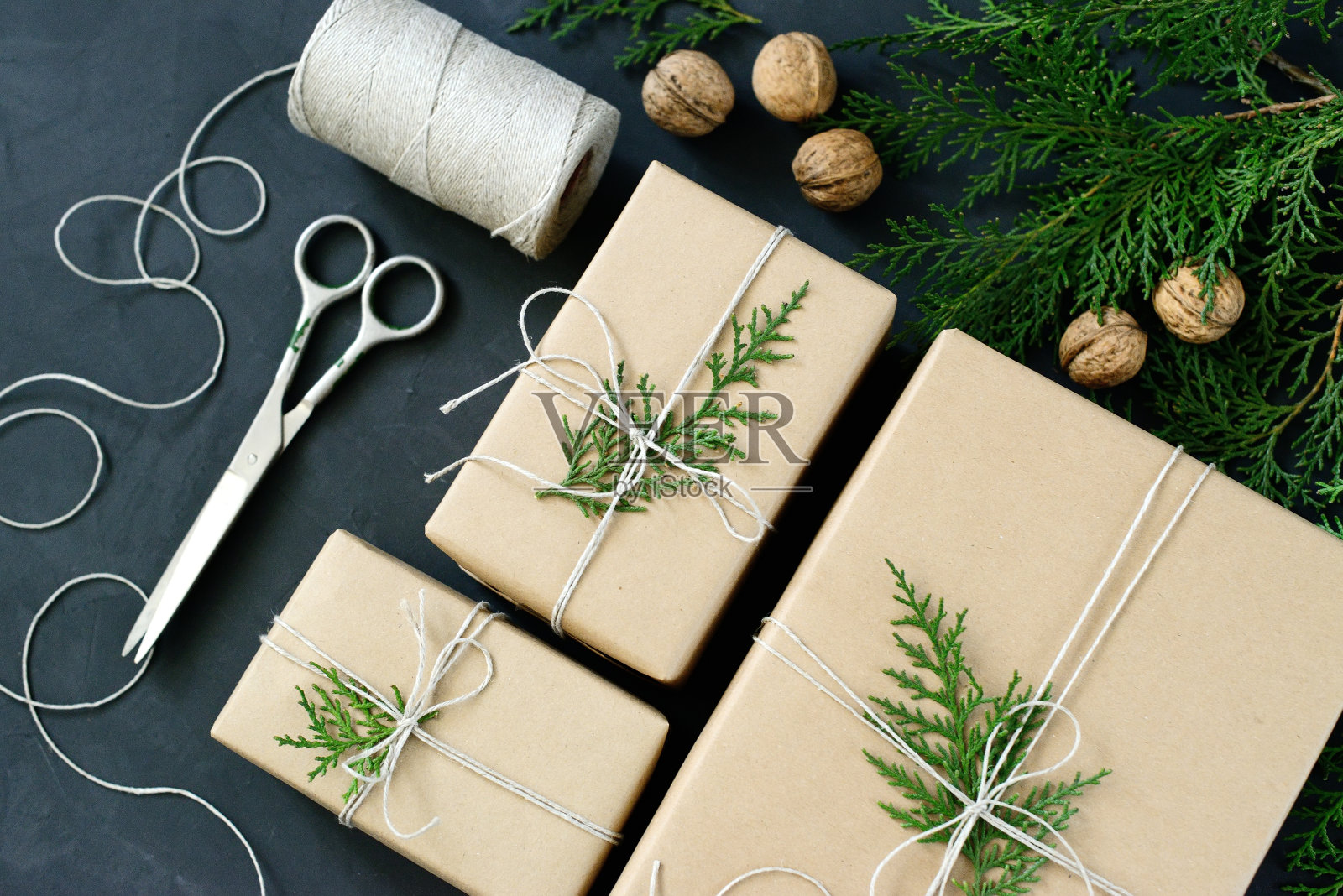 包装乡村生态圣诞礼物与牛皮纸，绳子和照片摄影图片