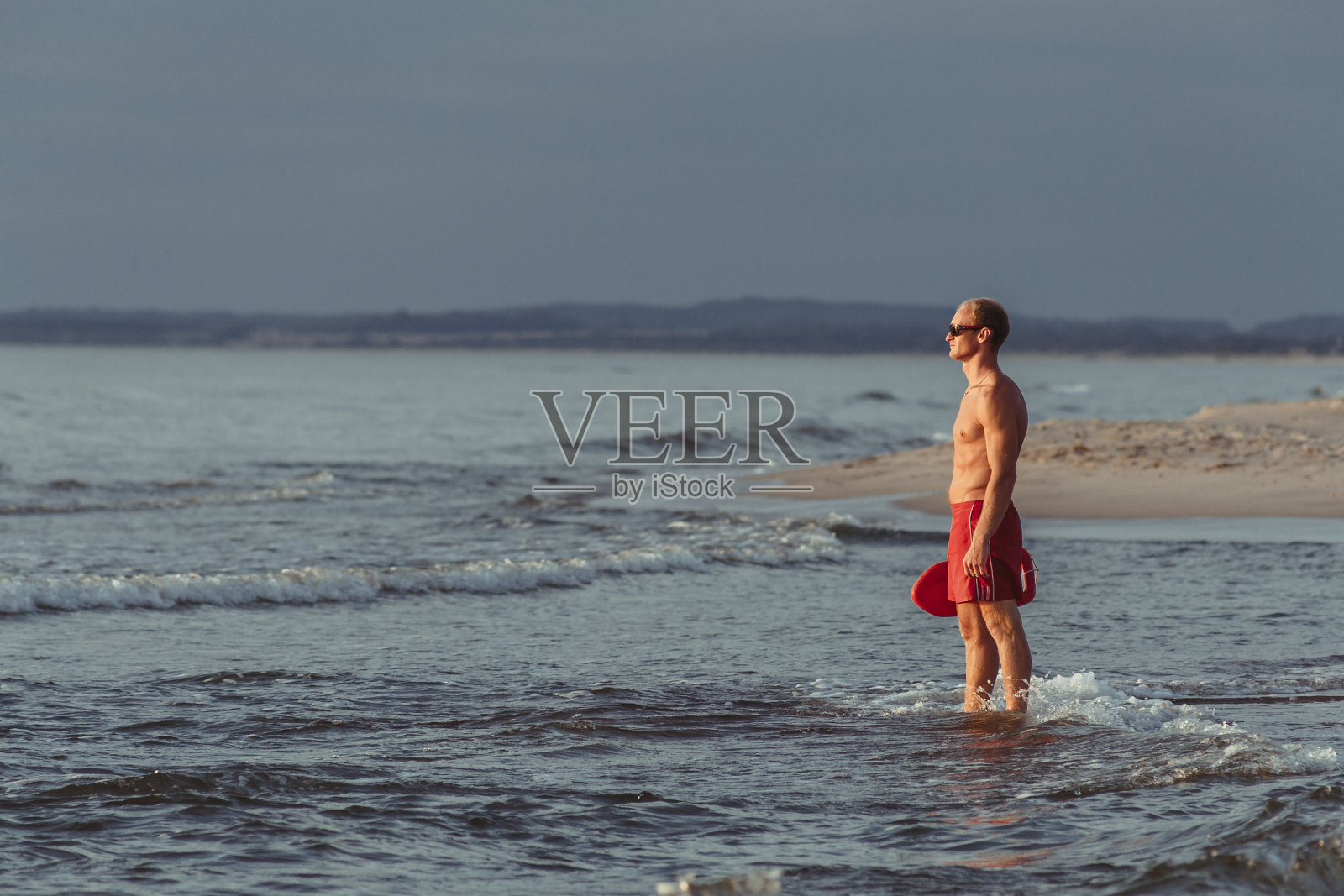 海滩上的救生员戴着眼镜，带着救生圈照片摄影图片