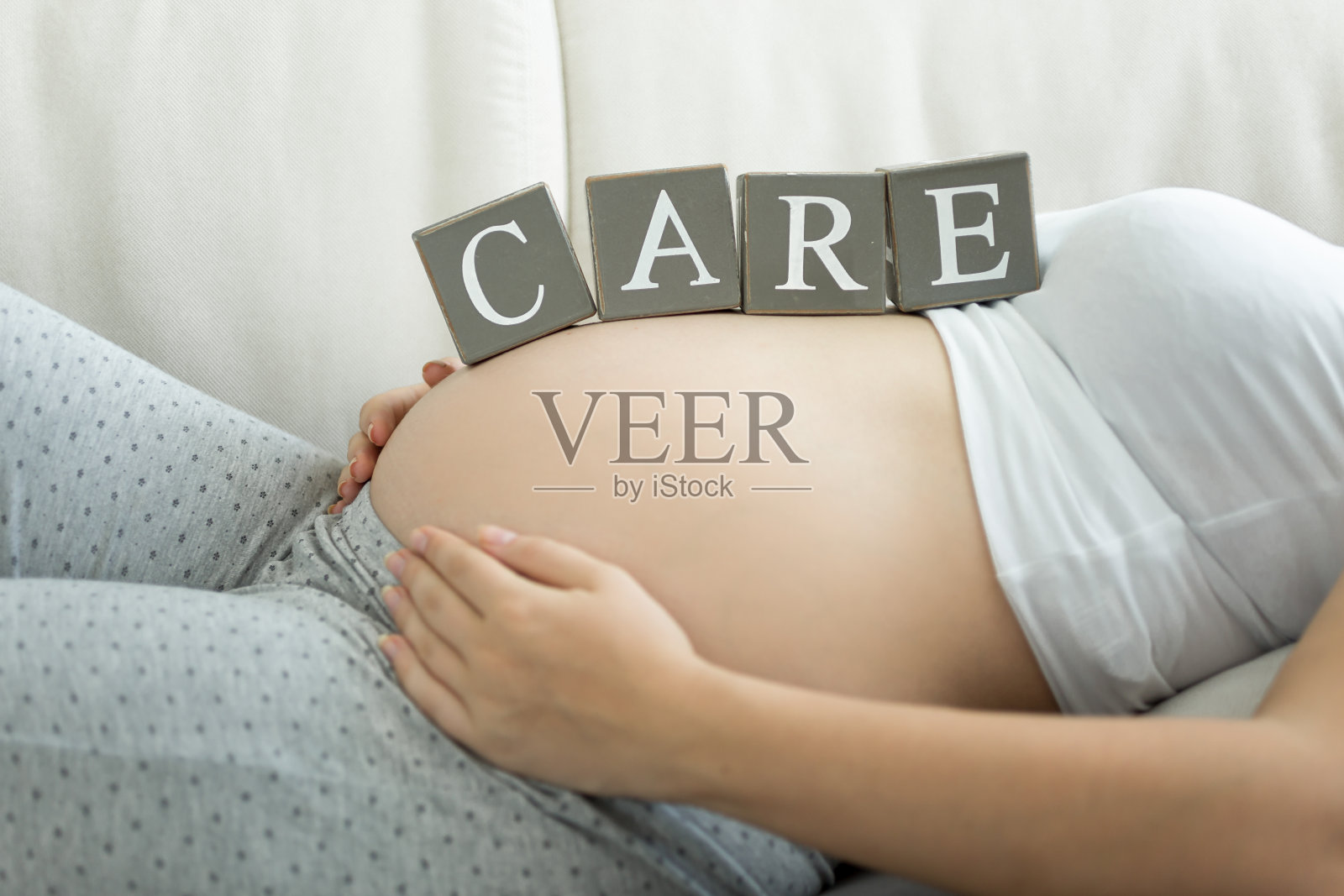 在积木上写着“孕妇肚子上的关爱”照片摄影图片