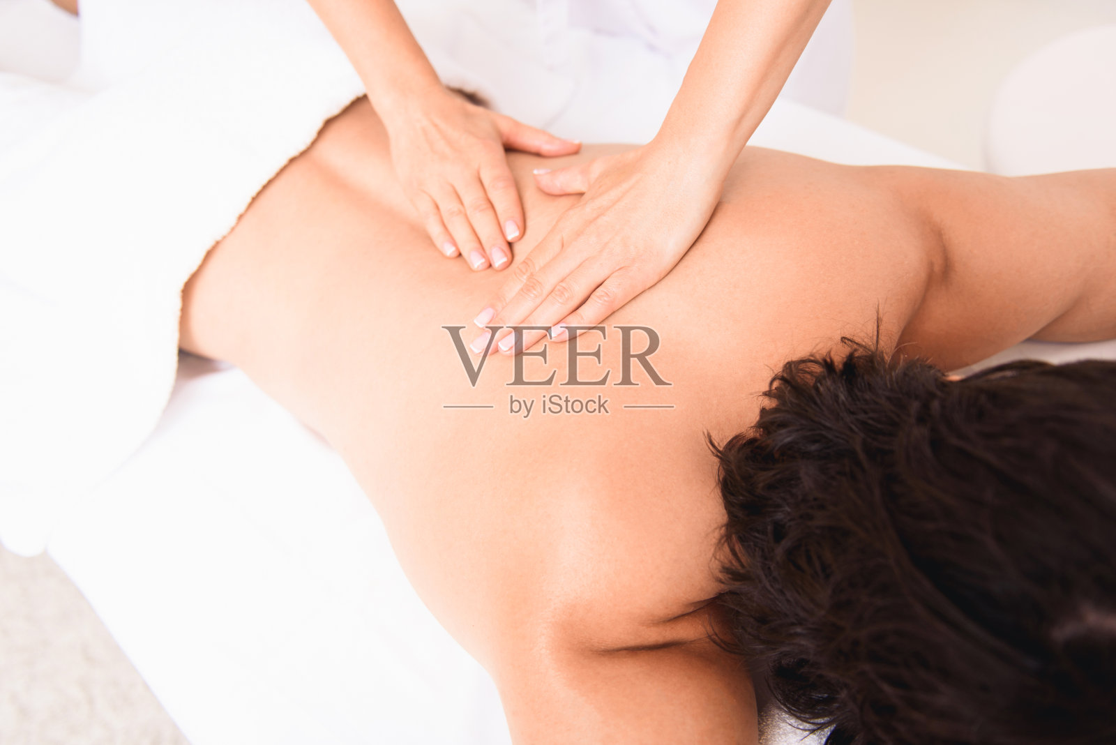 熟练的按摩师在沙龙为客户按摩照片摄影图片