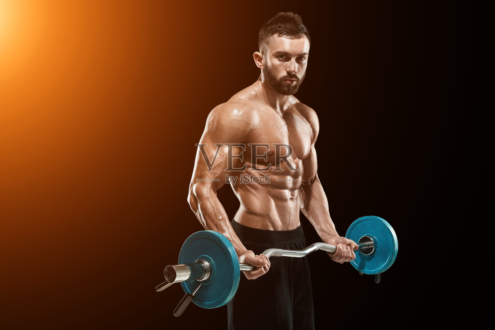 肌肉发达的男子在黑暗的背景下举重照片摄影图片