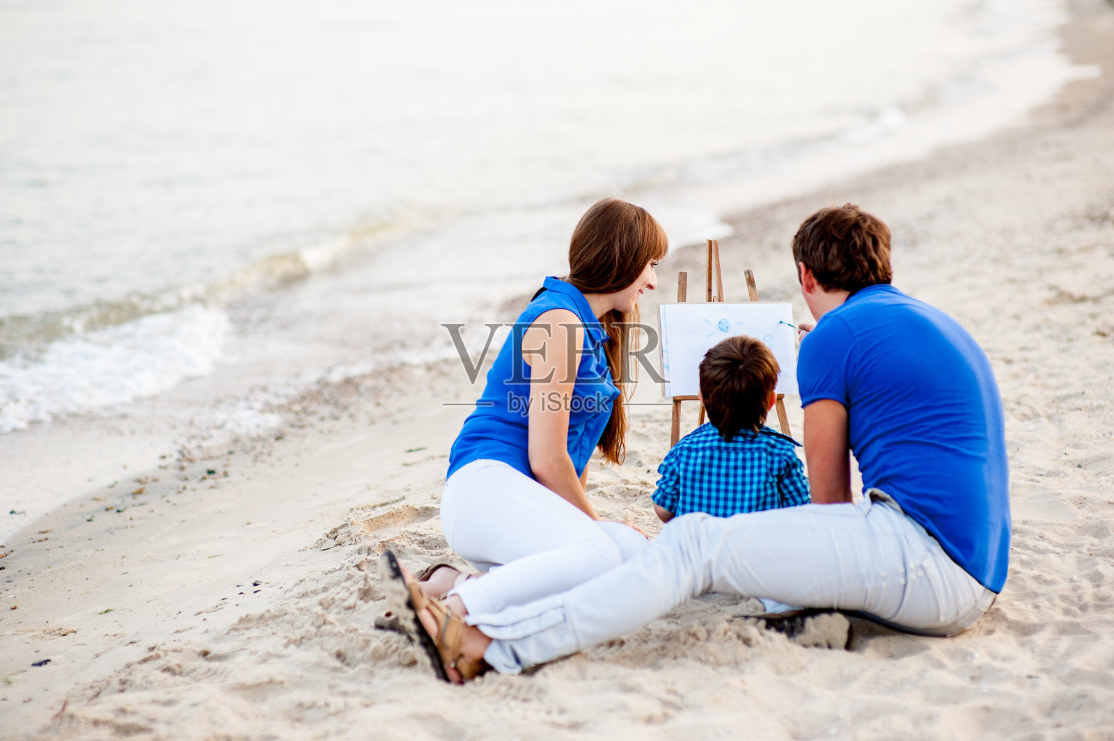 一家人在海边休息。照片摄影图片