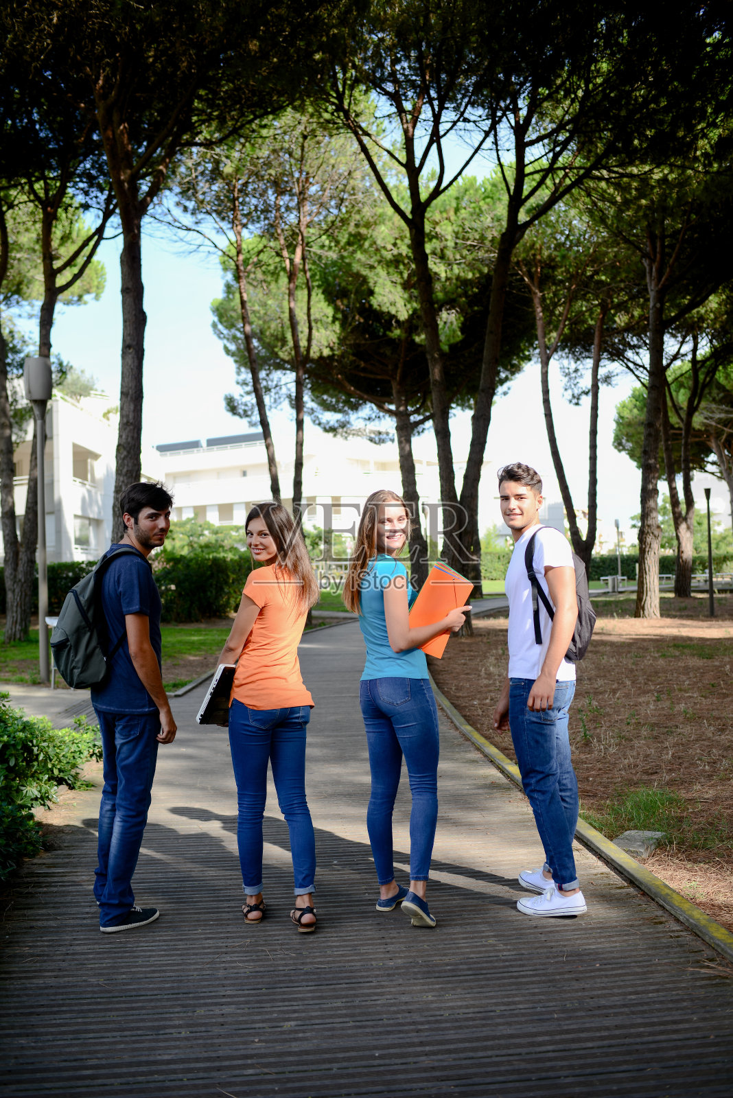 一群年轻的学生一起走在高中大学校园里照片摄影图片