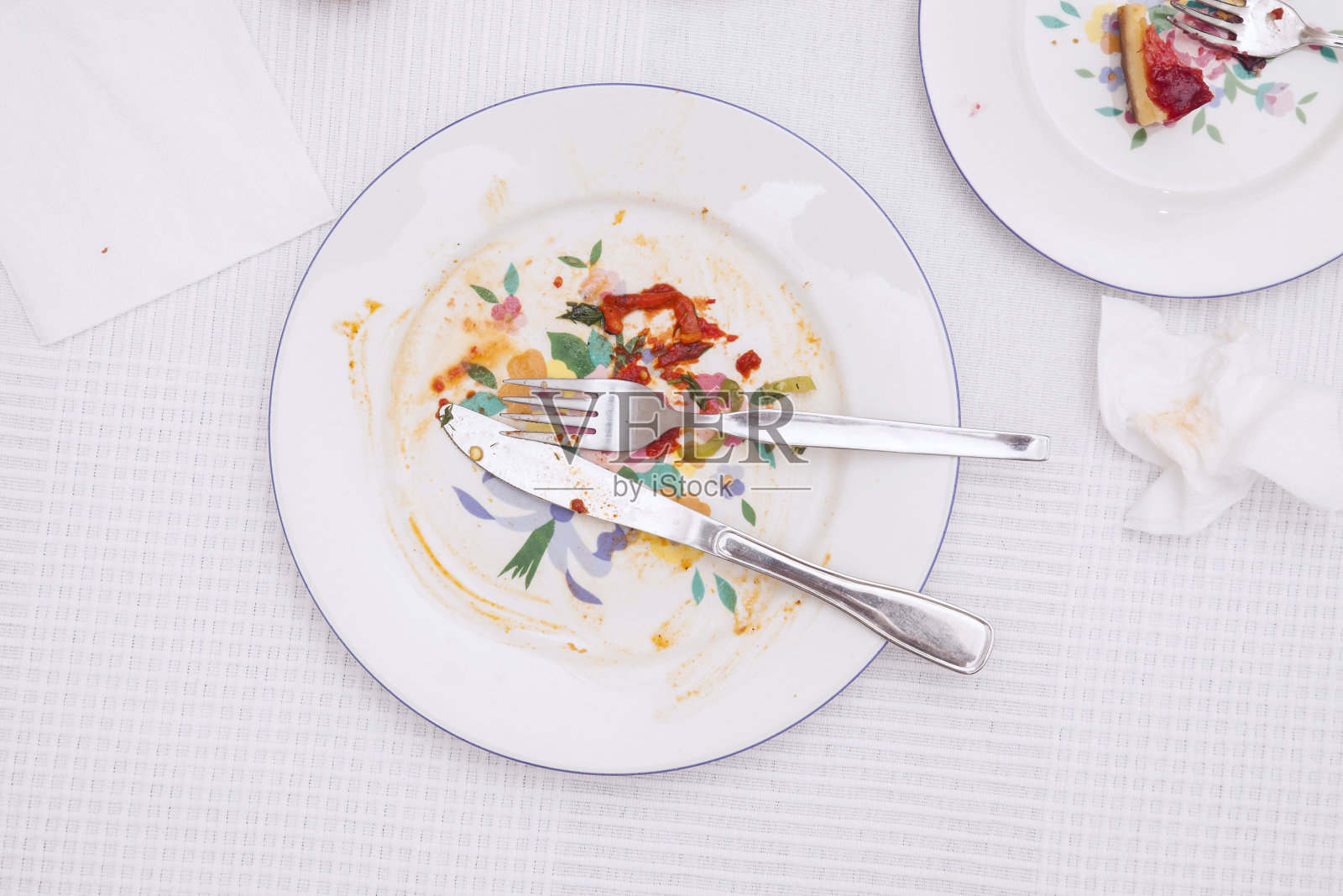 白色桌布上瓷盘上的剩余物照片摄影图片
